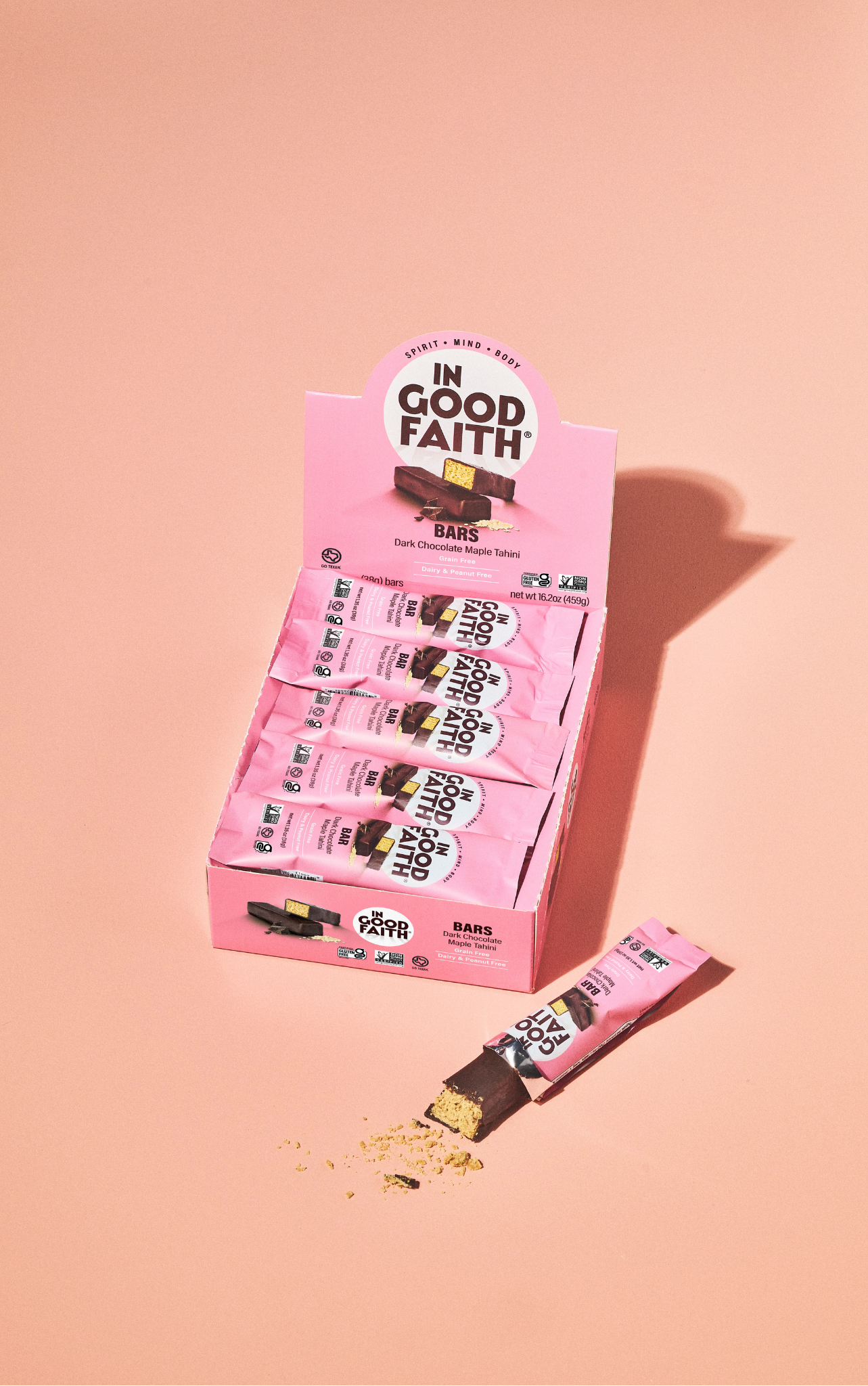 Box of 'In Good Faith' candy bars on a pink background